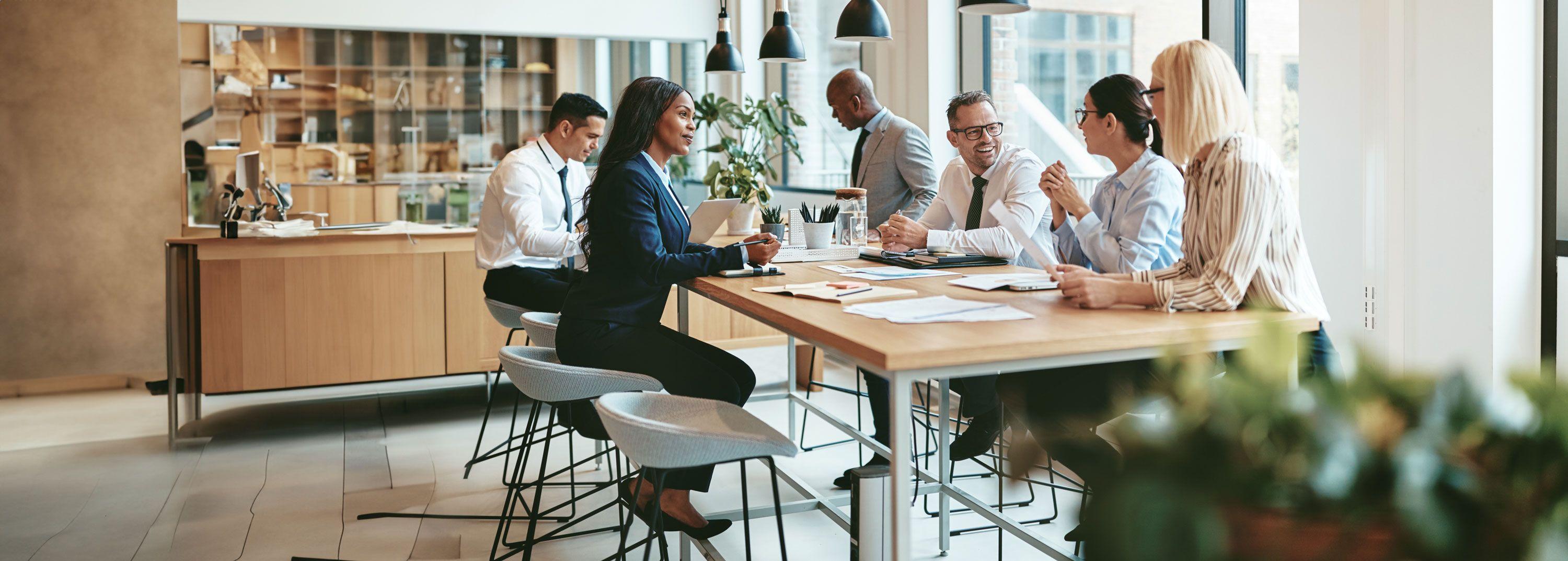 Six people having a business meeting around a table