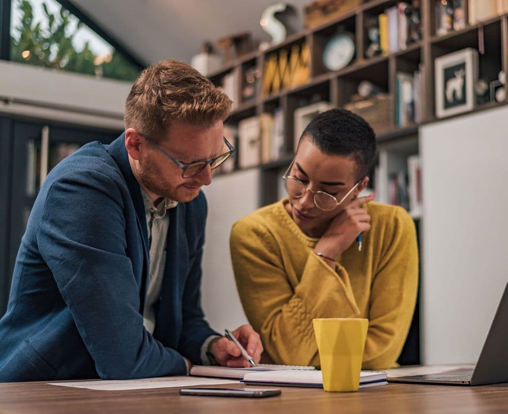 Two people reviewing contents on a piece of paper