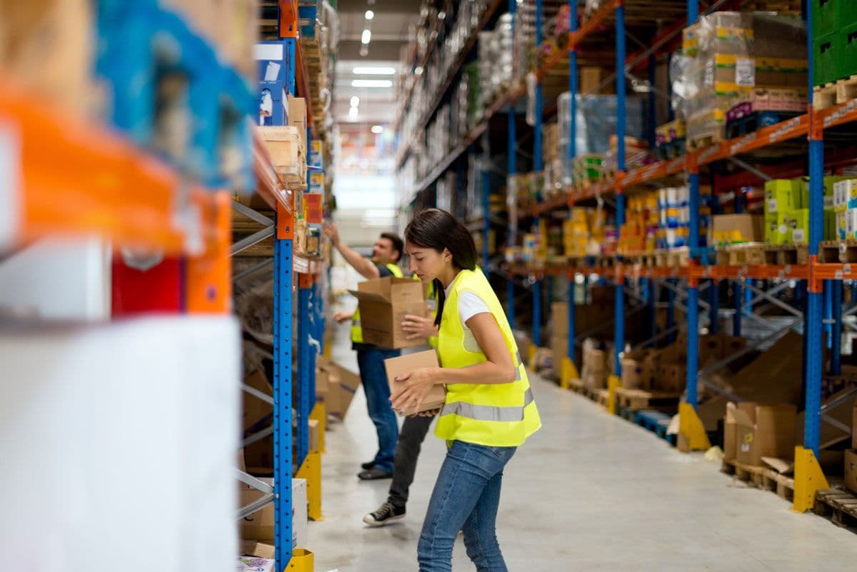 Two warehouse workers collecting items to pack into boxes